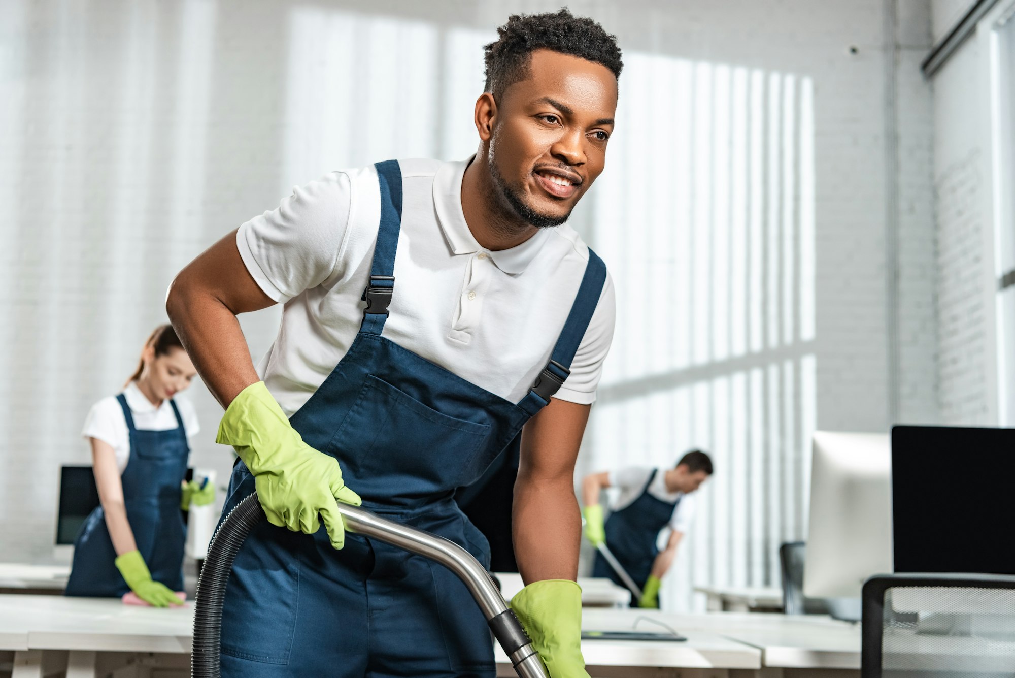 overhead view of young cleaner cleaning floor in office