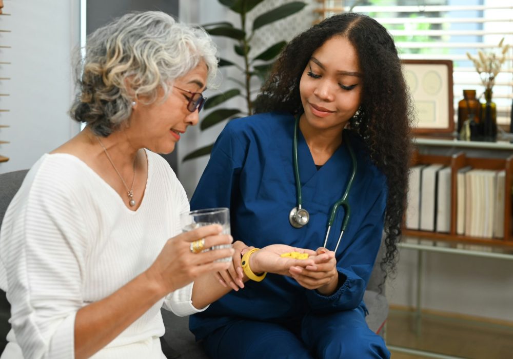 Healthcare worker or caregiver explaining medicine dosage to senior woman.